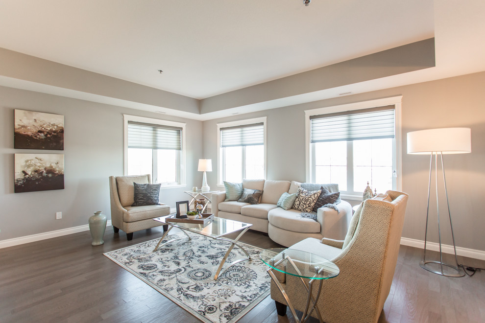 This is an example of a mid-sized transitional open concept living room in Other with grey walls, light hardwood floors, no fireplace and a freestanding tv.