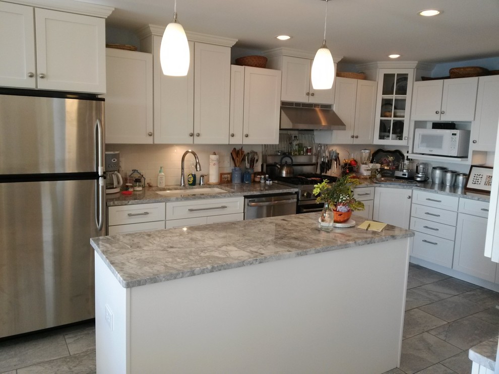 Mid-sized elegant u-shaped eat-in kitchen photo in Bridgeport with an undermount sink, shaker cabinets, white cabinets, marble countertops, white backsplash, ceramic backsplash, stainless steel appliances and an island