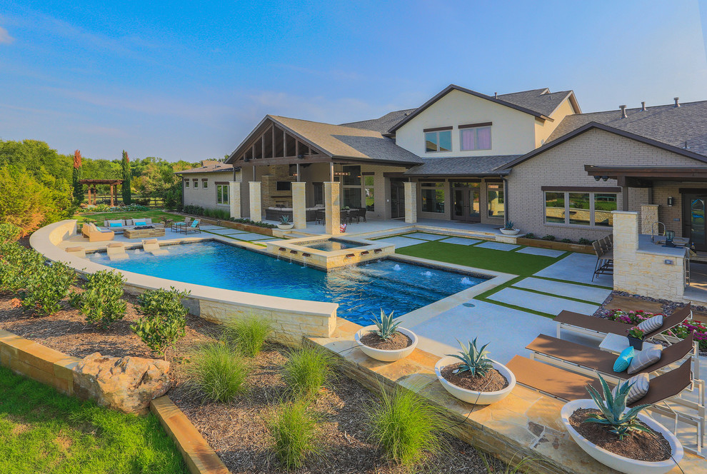 This is an example of a large transitional backyard l-shaped lap pool in Dallas with concrete slab and a hot tub.