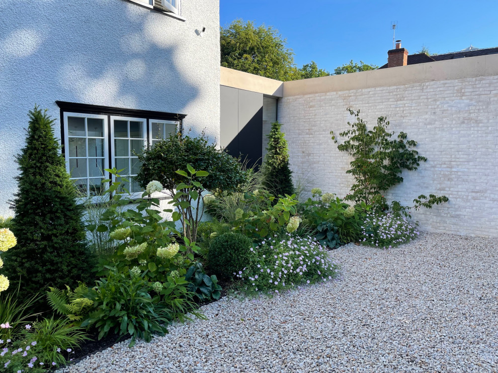 Geometrischer, Geräumiger Nordischer Vorgarten im Sommer mit Hochbeet, direkter Sonneneinstrahlung, Natursteinplatten und Holzzaun in London