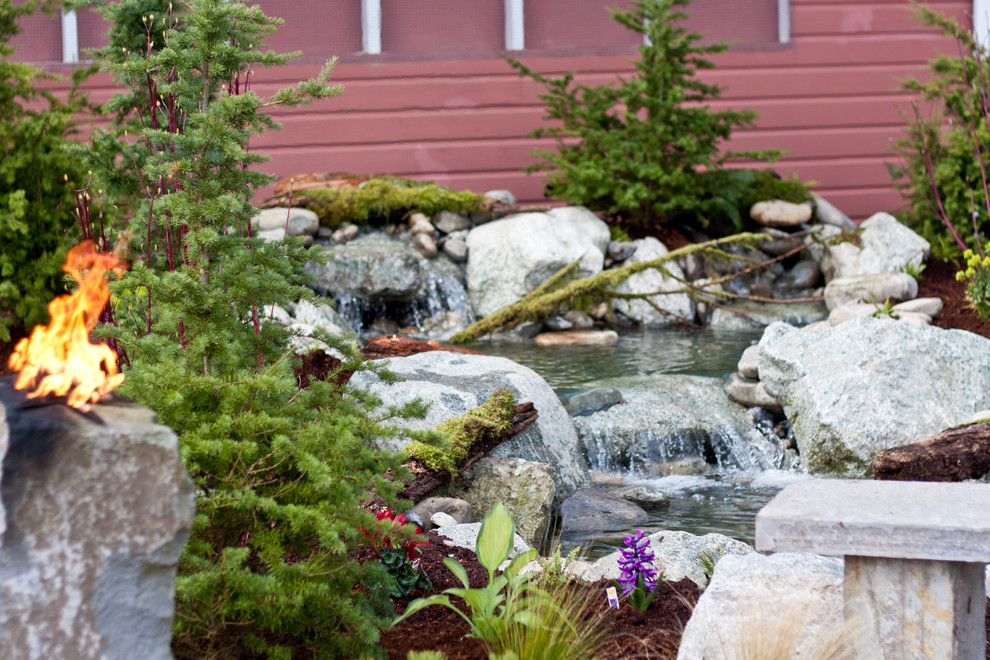 This is an example of a mid-sized rustic partial sun backyard stone formal garden in Seattle for spring.