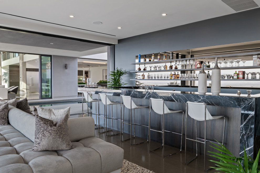 Imagen de bar en casa con fregadero en U moderno extra grande con salpicadero con efecto espejo y suelo gris