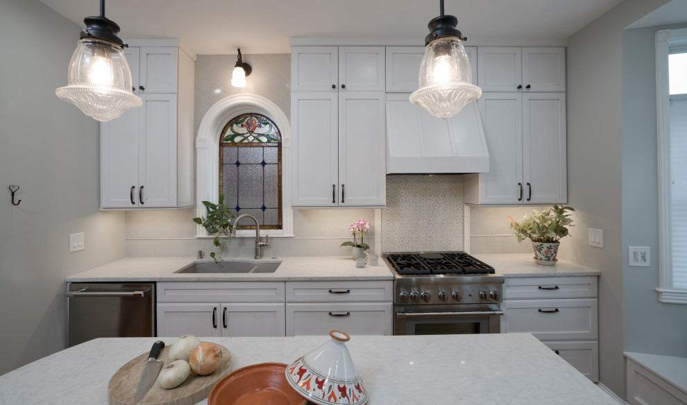 Design ideas for a mid-sized traditional galley separate kitchen in DC Metro with a double-bowl sink, recessed-panel cabinets, green cabinets, quartz benchtops, green splashback, ceramic splashback, white appliances, medium hardwood floors, with island, brown floor and white benchtop.