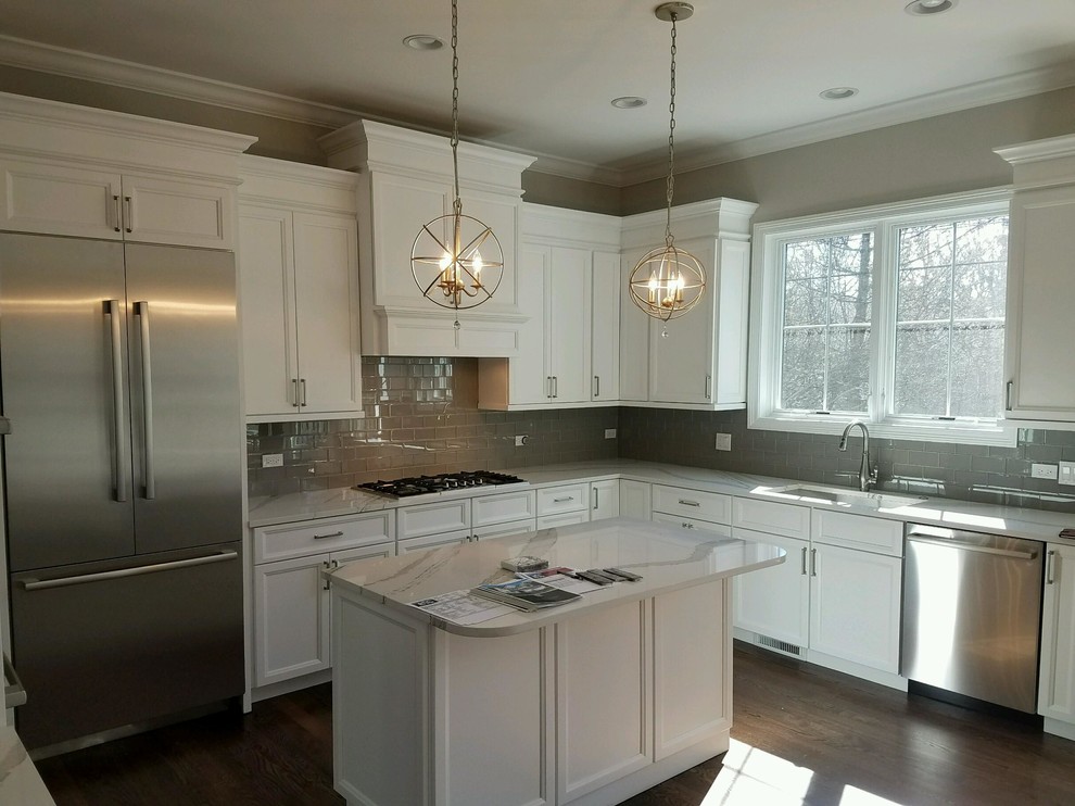 Mid-sized transitional l-shaped dark wood floor enclosed kitchen photo in Chicago with an undermount sink, shaker cabinets, white cabinets, quartz countertops, gray backsplash, subway tile backsplash, stainless steel appliances and an island