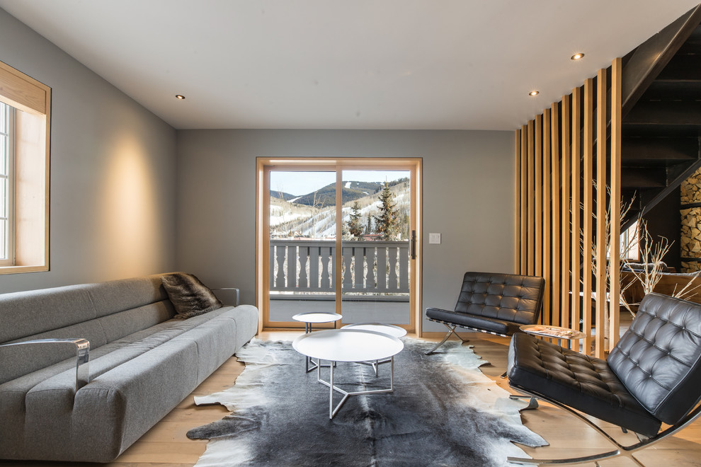Modern Living Room with Glass Window - A modern living room with a panoramic view of the mountains through the wood-framed glass door going to the balcony. The gray colored walls and ceiling makes this room sophisticated and spacious. While the gray sofa, black Barcelona chairs, and silver coffee tables complement its modish look. 

Built by ULFBUILT. Contact us to learn more.