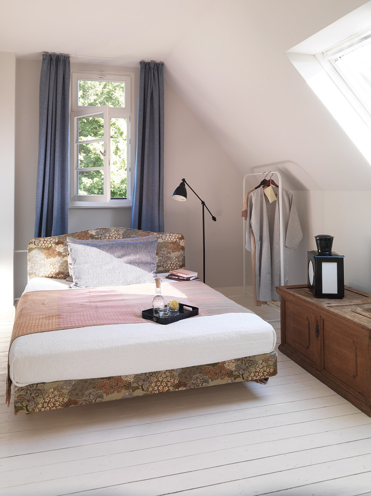 Photo of a small country guest bedroom in Berlin with white walls, light hardwood floors and no fireplace.