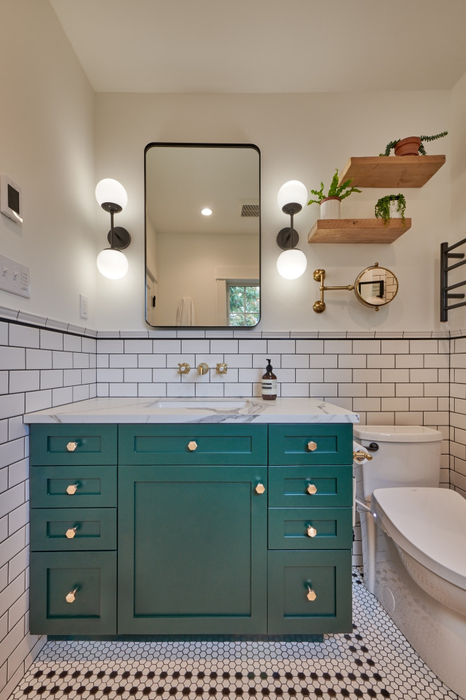 Badezimmer mit grünen Schränken, weißen Fliesen, Marmor-Waschbecken/Waschtisch, weißer Waschtischplatte, Wandnische und Einzelwaschbecken in Seattle