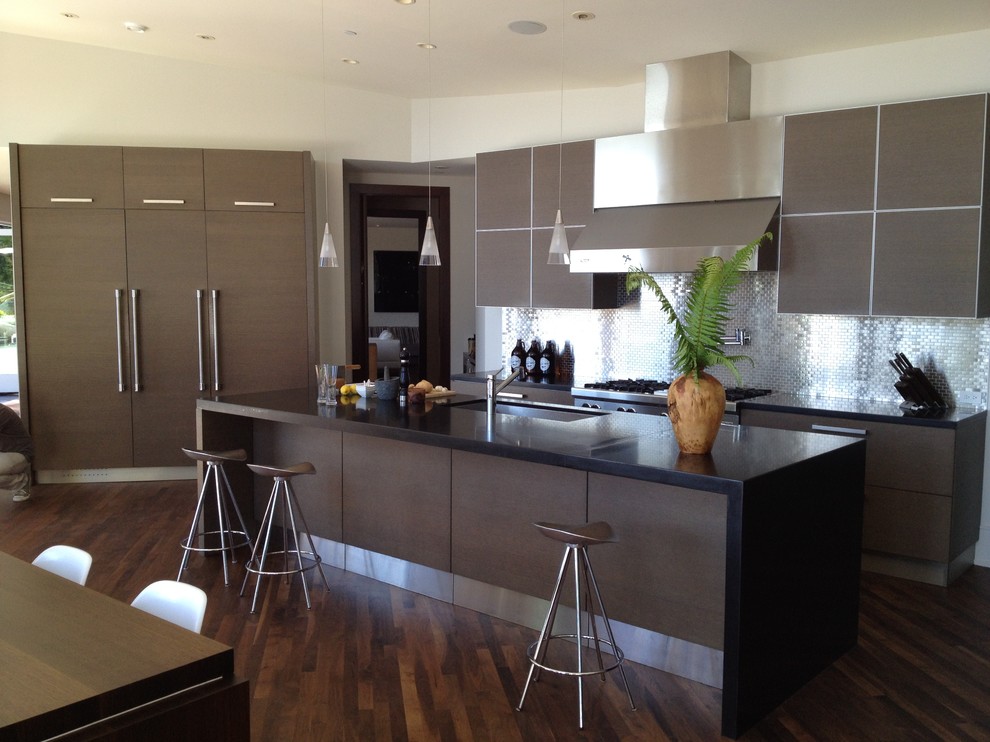 This is an example of a large contemporary u-shaped eat-in kitchen in Vancouver with an undermount sink, flat-panel cabinets, dark wood cabinets, metallic splashback, metal splashback, stainless steel appliances, dark hardwood floors and with island.