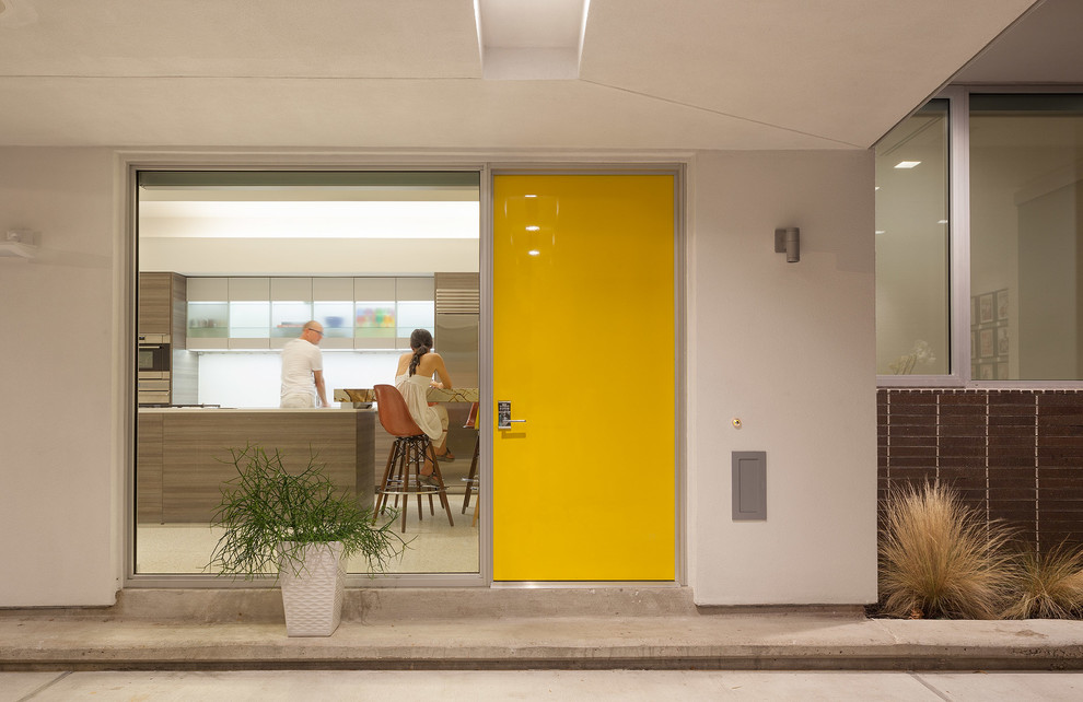 This is an example of a contemporary front door in Houston with a single front door and a yellow front door.