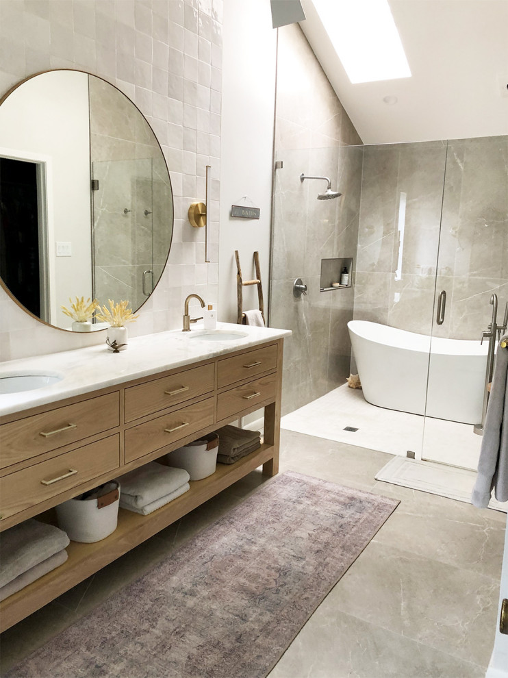 Modern master wet room bathroom in Dallas with flat-panel cabinets, light wood cabinets, a freestanding tub, white tile, ceramic tile, white walls, porcelain floors, an undermount sink, marble benchtops, beige floor, a hinged shower door, white benchtops, a double vanity, a freestanding vanity and vaulted.