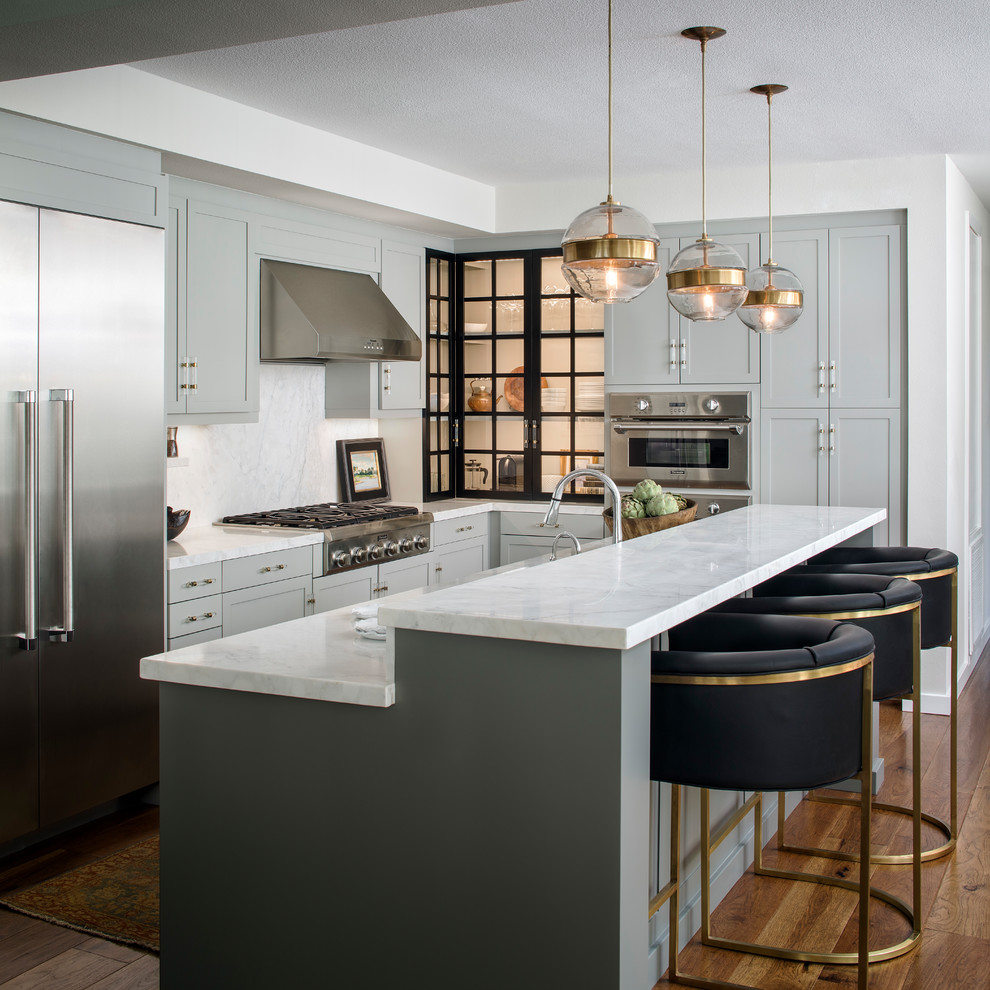 Inspiration for a mid-sized transitional l-shaped kitchen in San Francisco with shaker cabinets, grey cabinets, marble benchtops, marble splashback, stainless steel appliances, medium hardwood floors, with island, brown floor and white splashback.