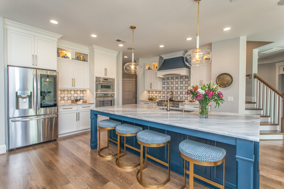 Large transitional l-shaped medium tone wood floor and beige floor kitchen photo in Other with an undermount sink, shaker cabinets, white cabinets, black backsplash, mosaic tile backsplash, stainless steel appliances, an island and gray countertops