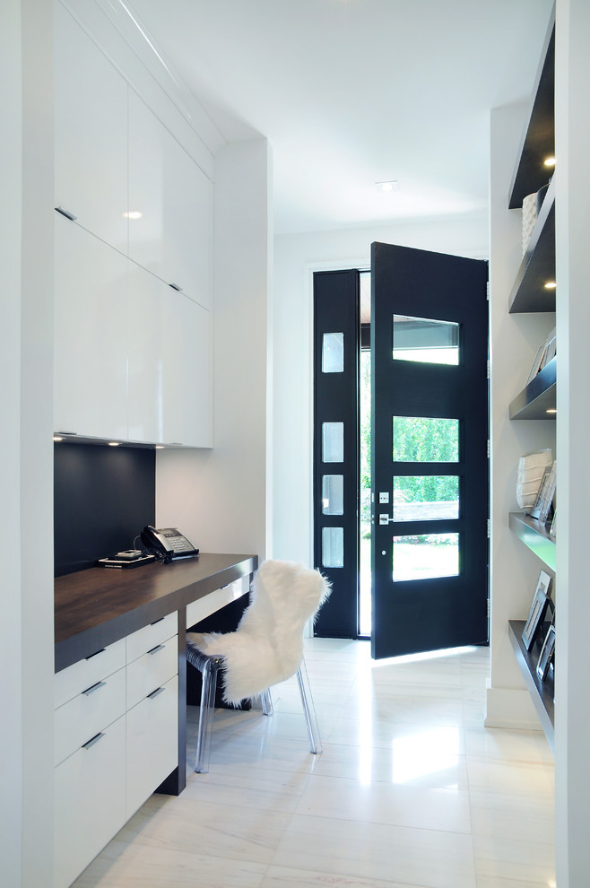 Photo of a mid-sized modern home office in Toronto with white walls and a built-in desk.