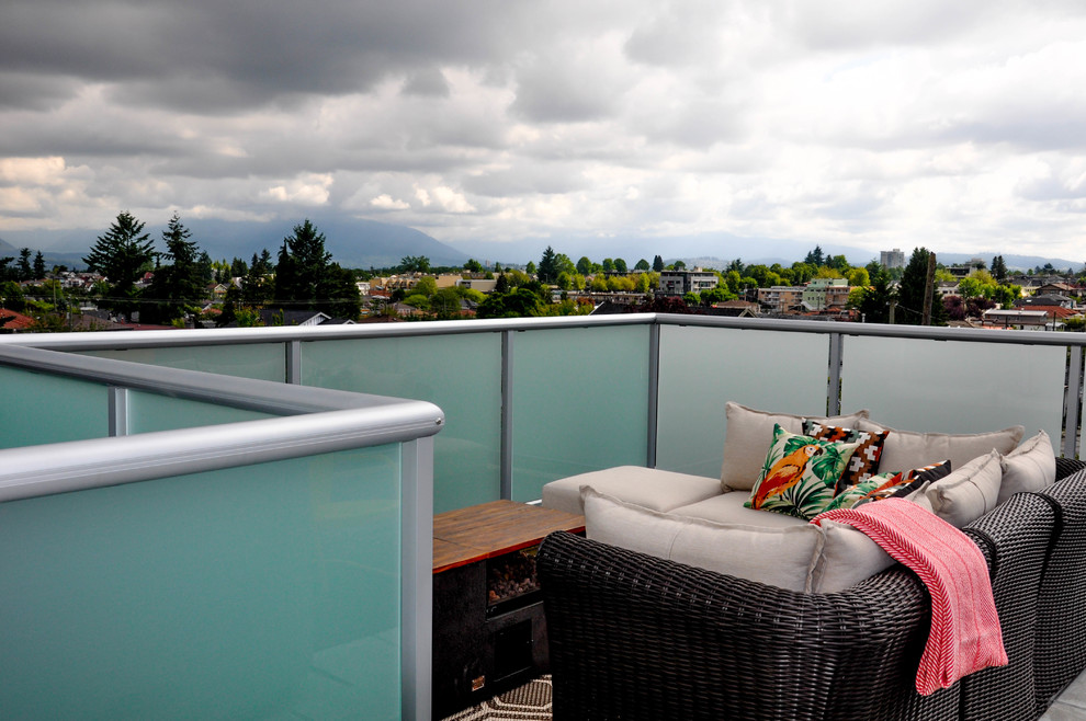 Photo of a mid-sized modern rooftop deck in Vancouver with a fire feature and no cover.