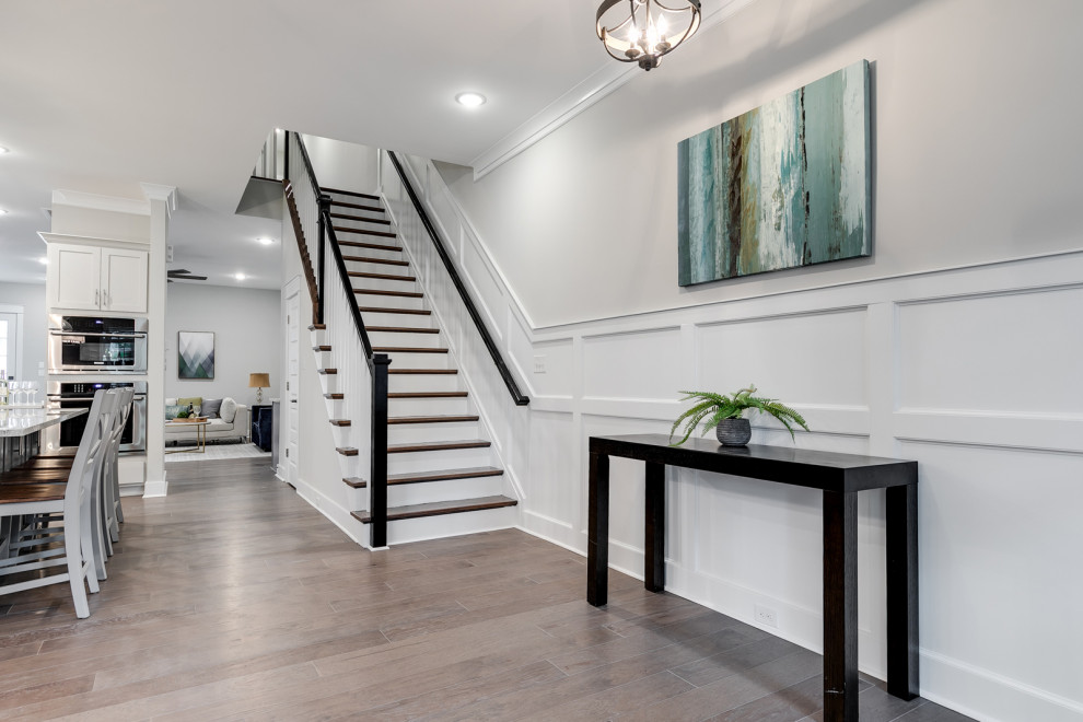 Mid-sized traditional foyer in Richmond with grey walls, medium hardwood floors, a single front door, a medium wood front door, brown floor and decorative wall panelling.