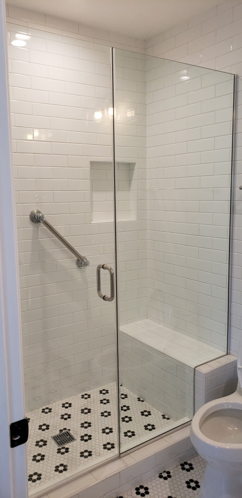 This is an example of a small modern ensuite bathroom in Los Angeles with shaker cabinets, white cabinets, a corner shower, a one-piece toilet, white tiles, metro tiles, white walls, mosaic tile flooring, a built-in sink, solid surface worktops, white floors, a hinged door, white worktops, a shower bench, a single sink and a floating vanity unit.