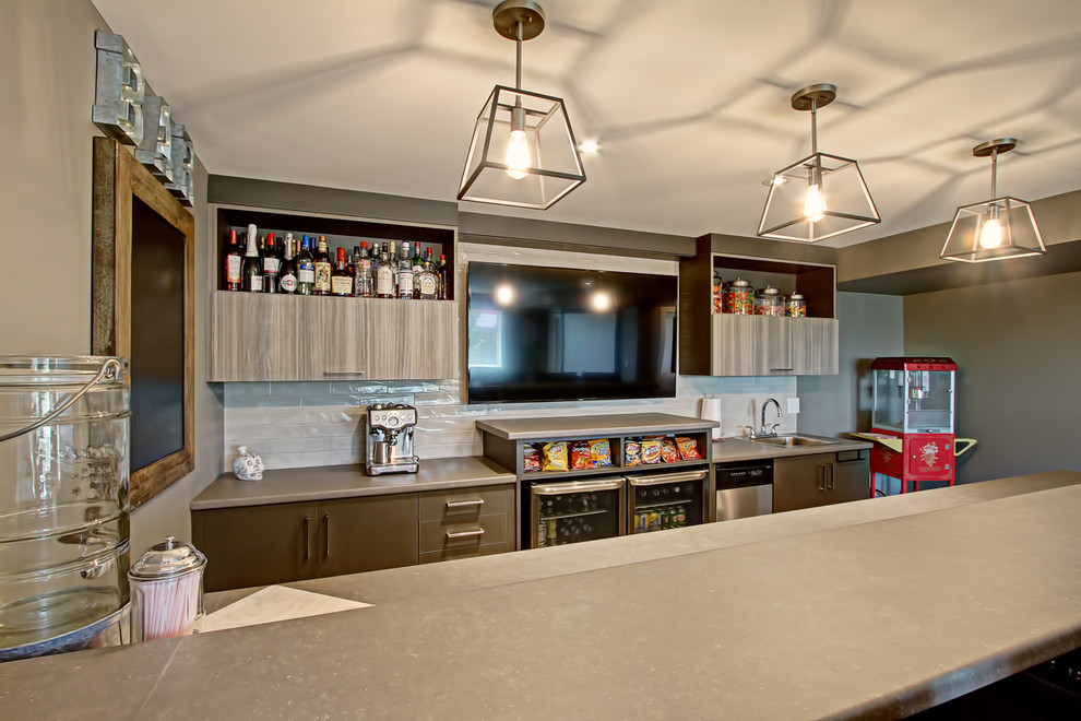 Mid-sized transitional galley seated home bar in Toronto with a drop-in sink, flat-panel cabinets, grey cabinets, concrete benchtops, white splashback, glass tile splashback, medium hardwood floors, beige floor and beige benchtop.