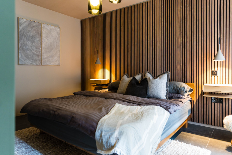 This is an example of a mid-sized modern master bedroom in London with ceramic floors, grey floor and panelled walls.