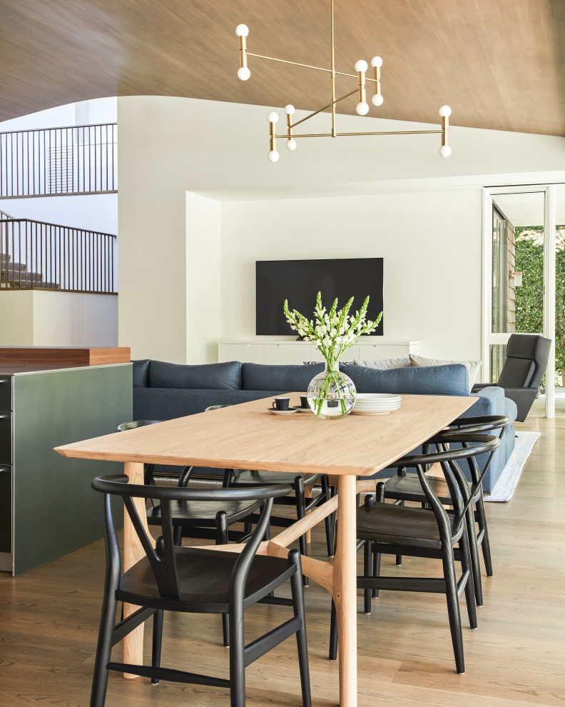 This is an example of an expansive open plan dining in Los Angeles with medium hardwood floors, brown floor and wood.