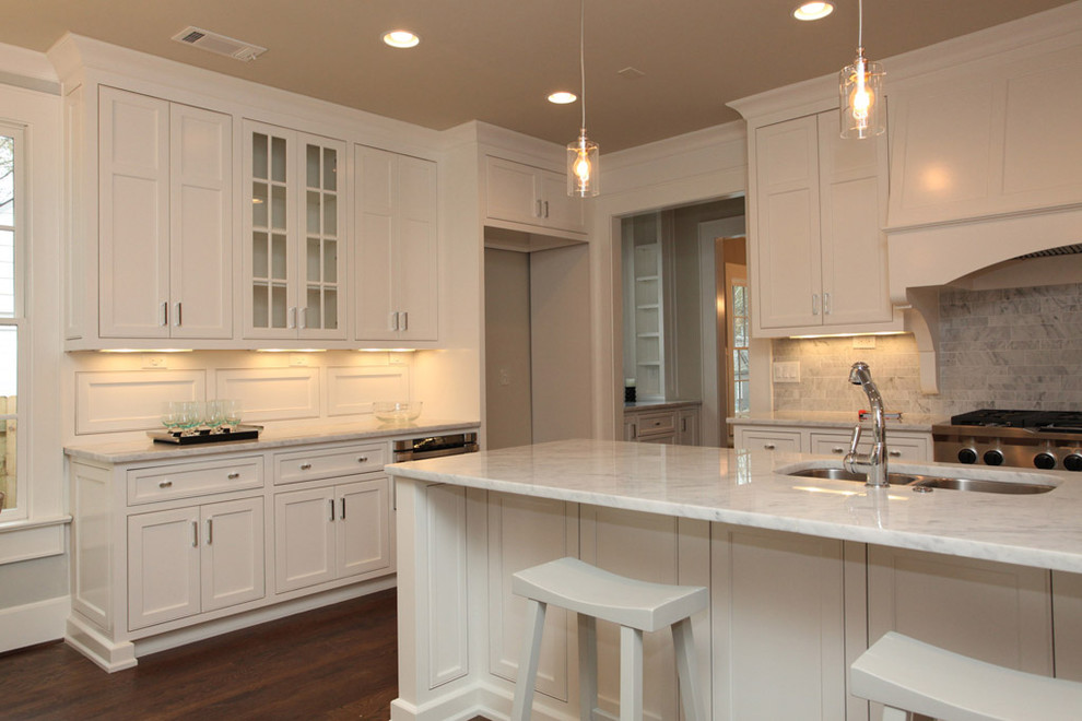 Photo of a traditional kitchen in Atlanta with recessed-panel cabinets, marble benchtops, white cabinets, white splashback and stone tile splashback.