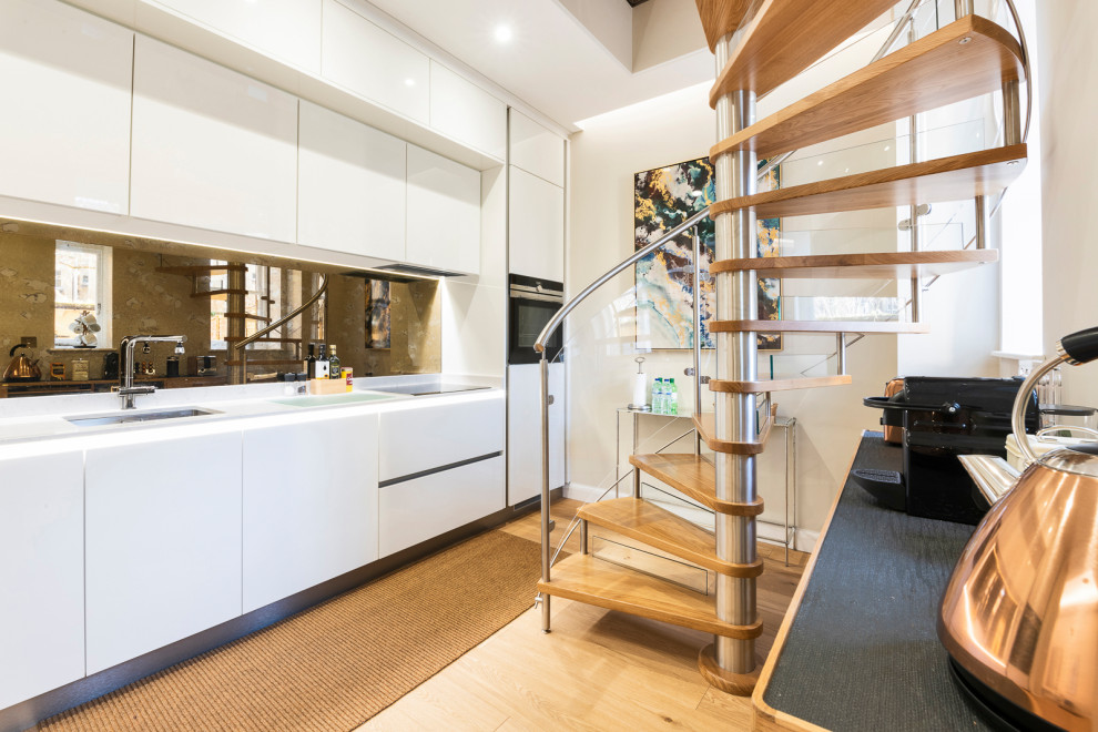 Aménagement d'un petit escalier hélicoïdal moderne avec des marches en bois, des contremarches en verre et un garde-corps en matériaux mixtes.