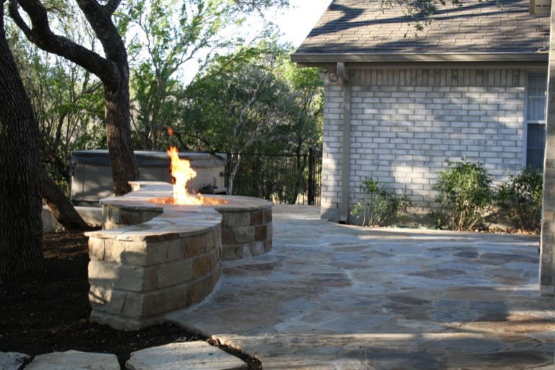 Inspiration for a large timeless backyard stone patio remodel in Austin with a fire pit