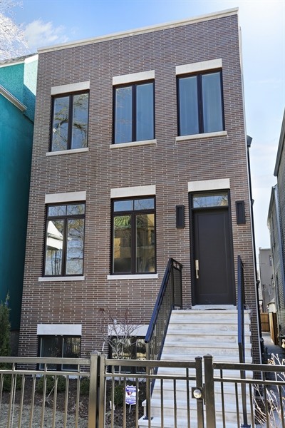 This is an example of a large modern three-storey brick brown exterior in Chicago with a flat roof.