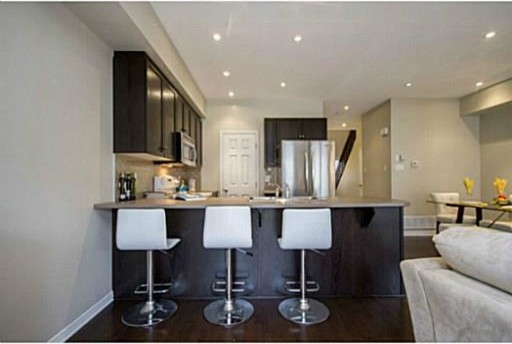 Inspiration for a mid-sized contemporary u-shaped dark wood floor and brown floor eat-in kitchen remodel in Ottawa with shaker cabinets, dark wood cabinets, quartz countertops, beige backsplash, a peninsula, a drop-in sink, ceramic backsplash and stainless steel appliances