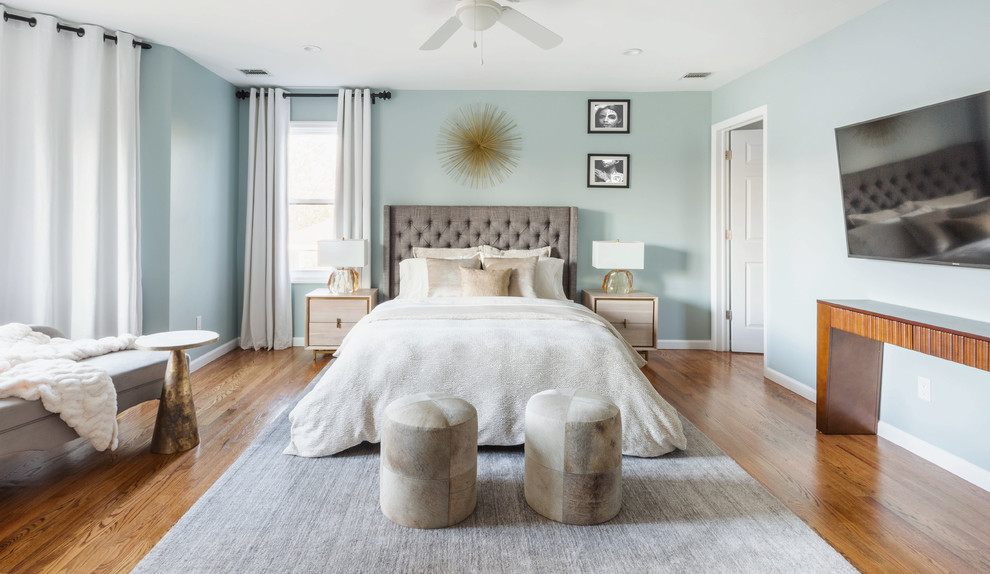Design ideas for a large transitional master bedroom in New York with grey walls, medium hardwood floors, no fireplace and brown floor.