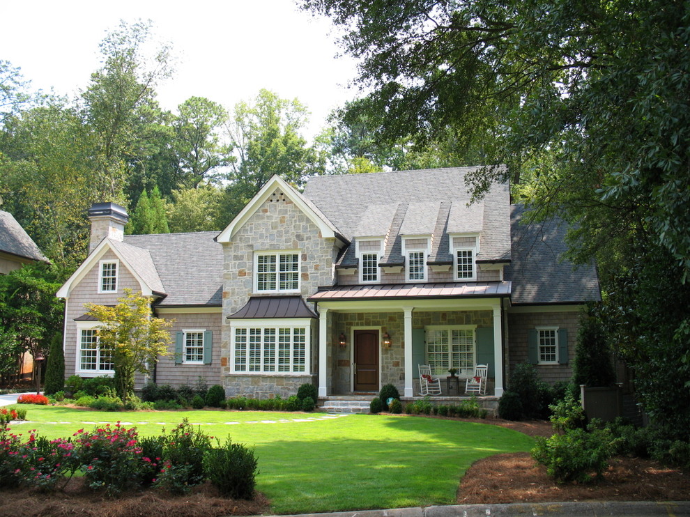 This is an example of a mid-sized traditional two-storey grey exterior in Atlanta with stone veneer and a gable roof.