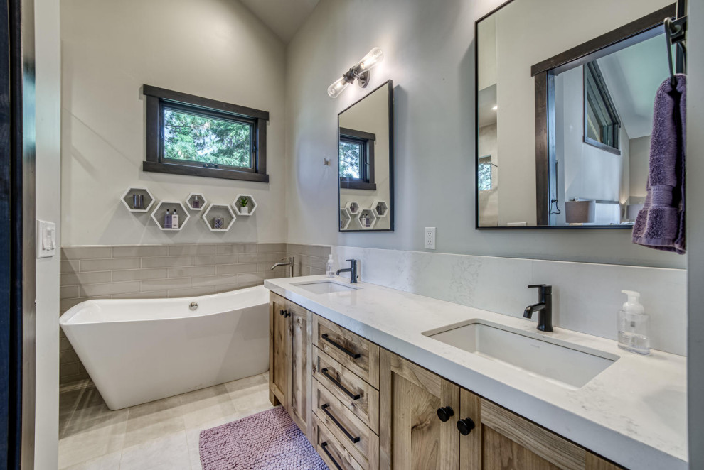 Country bathroom in Boise with shaker cabinets, distressed cabinets, a freestanding tub, ceramic floors, an undermount sink, quartzite benchtops, grey floor, white benchtops, a double vanity and a built-in vanity.