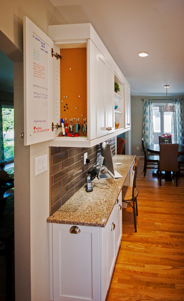 Eat-in kitchen - mid-sized transitional l-shaped light wood floor eat-in kitchen idea with a double-bowl sink, shaker cabinets, white cabinets, quartz countertops, brown backsplash, ceramic backsplash, stainless steel appliances and an island