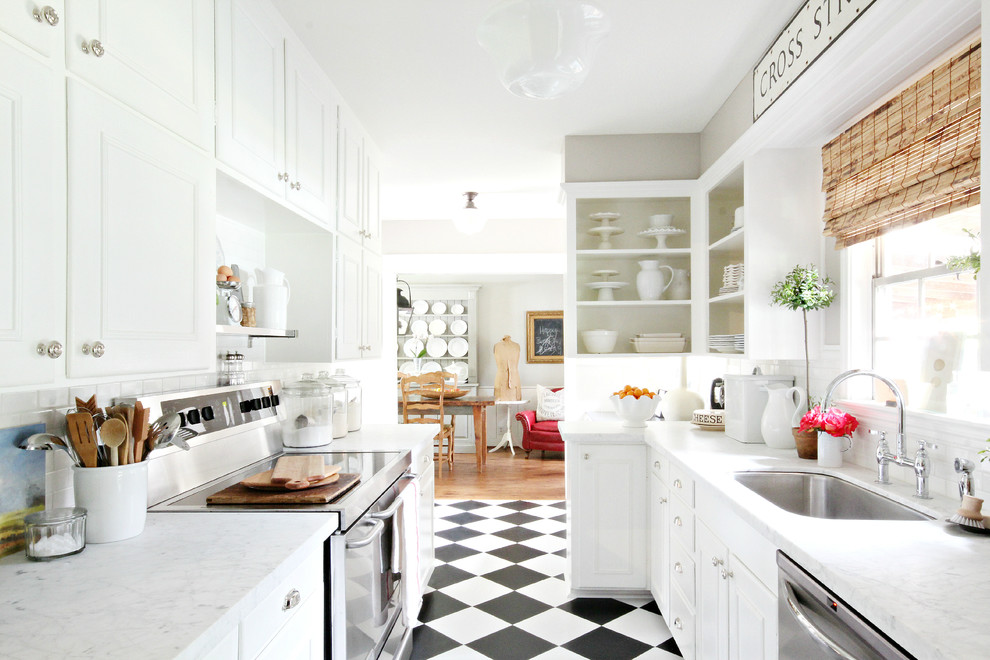 Small traditional galley separate kitchen in Houston with a single-bowl sink, recessed-panel cabinets, white cabinets, white splashback, subway tile splashback, stainless steel appliances and multi-coloured floor.