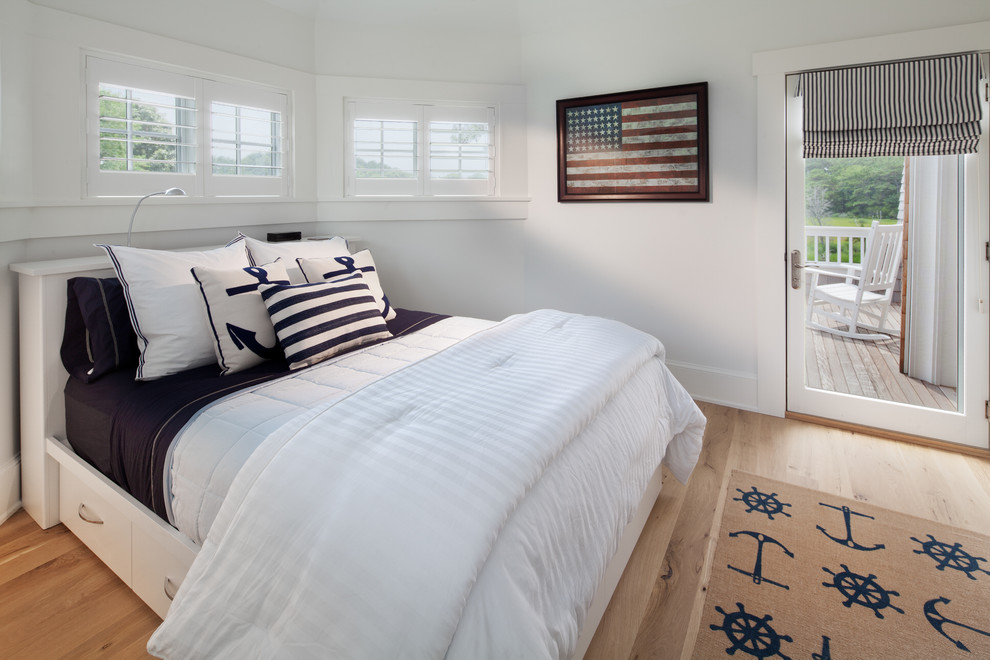 Example of a beach style medium tone wood floor bedroom design in DC Metro with white walls
