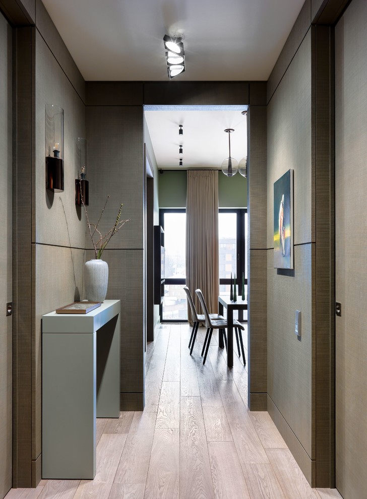 Photo of a mid-sized contemporary entry hall in Moscow with medium hardwood floors, brown floor and grey walls.