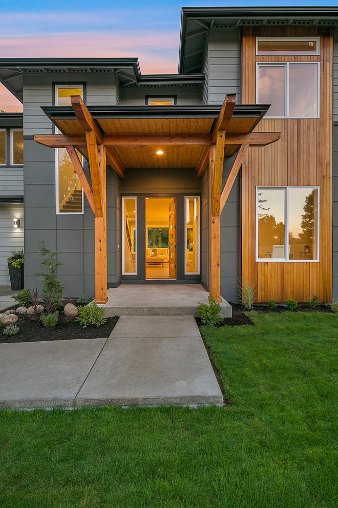 This is an example of a modern front yard verandah in Seattle with with columns and a roof extension.