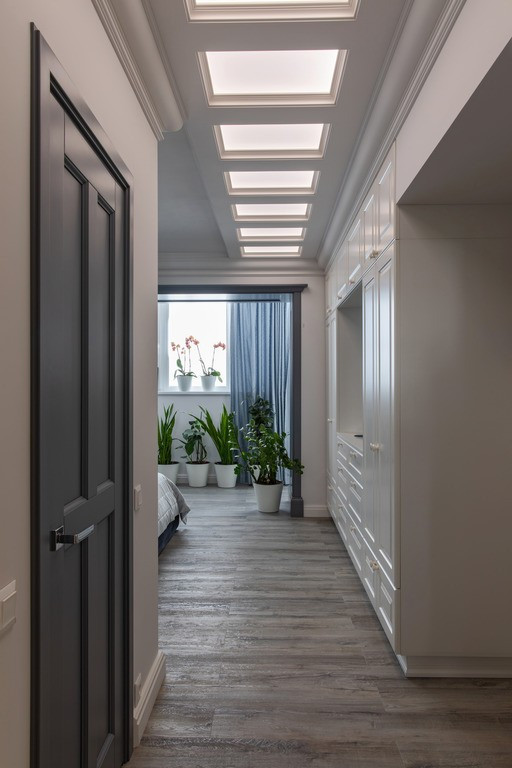 Idee per una camera matrimoniale tradizionale di medie dimensioni con pareti bianche, pavimento in laminato e pavimento grigio
