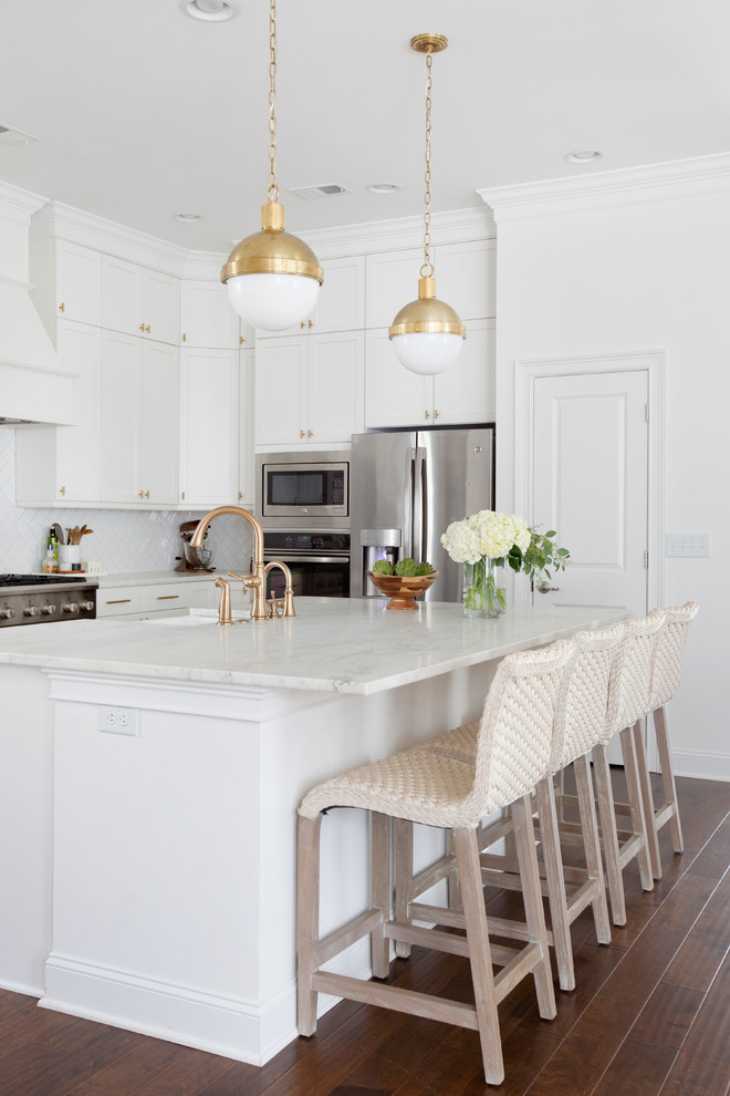 Inspiration for a traditional kitchen in Charleston with an undermount sink, white cabinets, white splashback, stainless steel appliances, medium hardwood floors and with island.