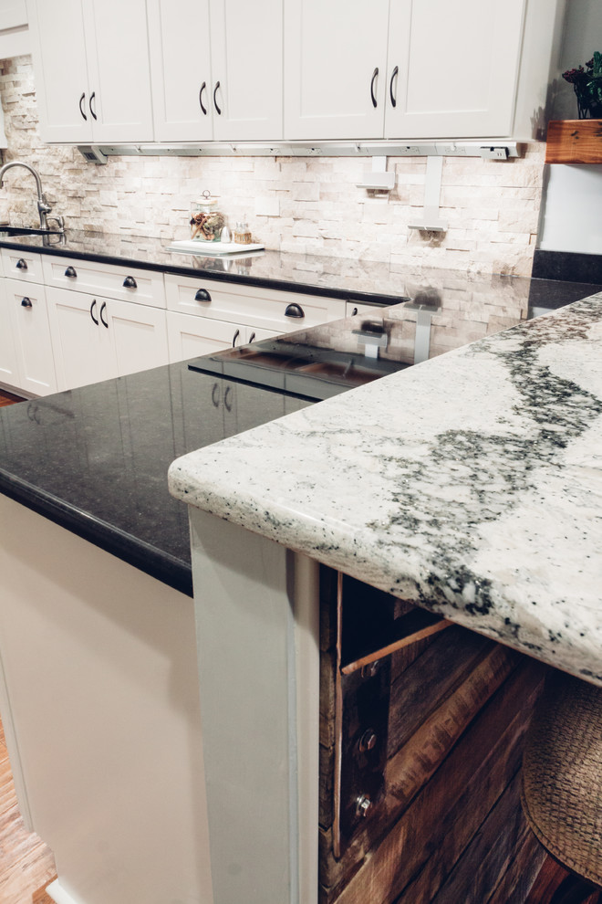 Inspiration for a large transitional galley light wood floor and brown floor open concept kitchen remodel with an undermount sink, shaker cabinets, white cabinets, quartz countertops, white backsplash, stone tile backsplash, stainless steel appliances and a peninsula