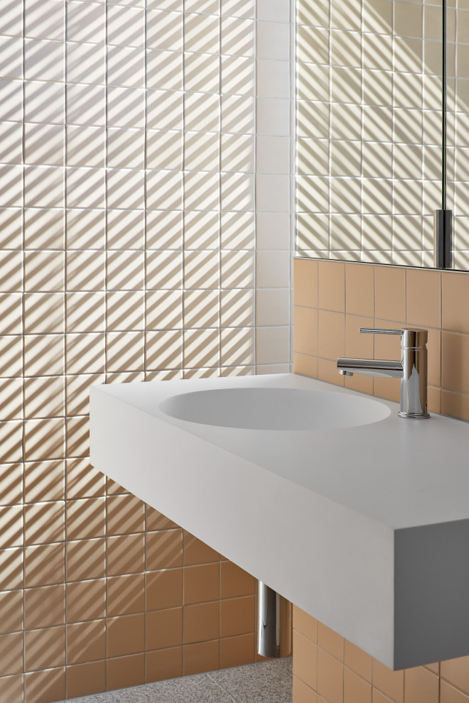 Стильный дизайн: туалет среднего размера в стиле модернизм с белыми фасадами, оранжевой плиткой и подвесной тумбой - последний тренд