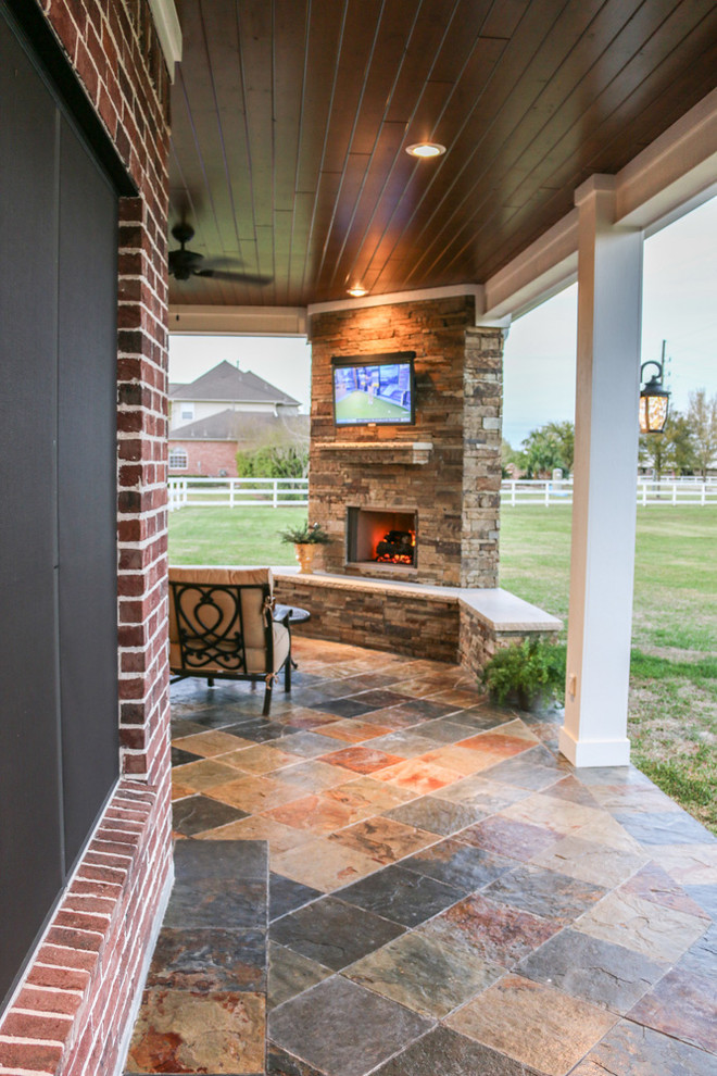 This is an example of a large traditional backyard patio in Houston with an outdoor kitchen, tile and a roof extension.