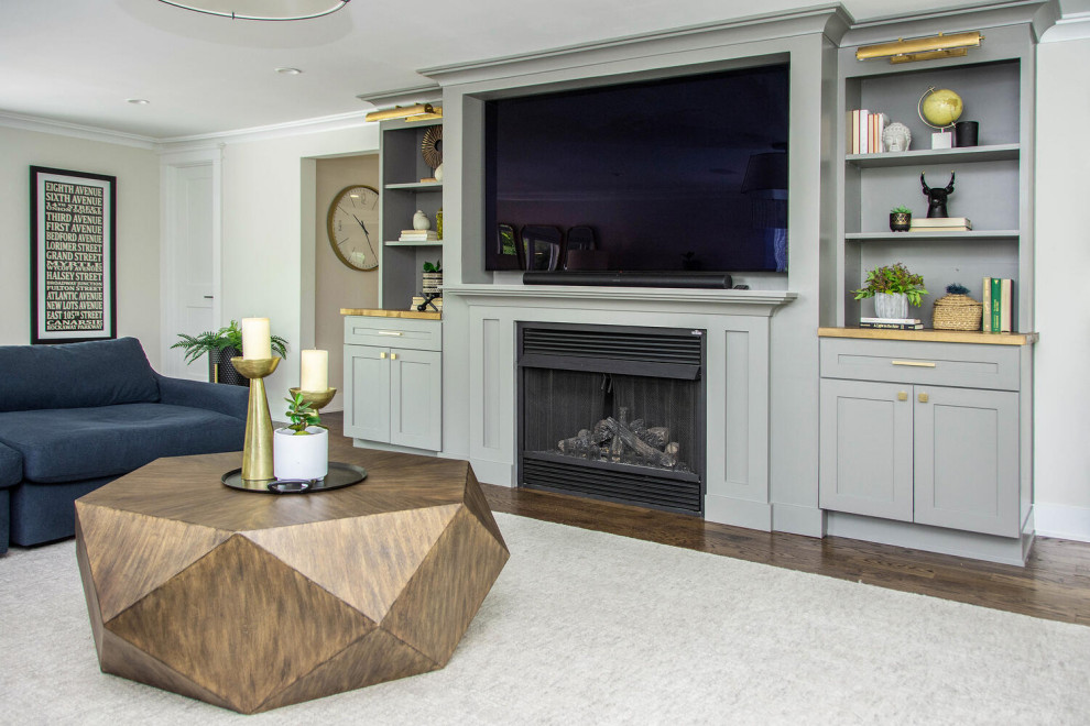 Exemple d'un grand salon tendance fermé avec un sol en bois brun, un manteau de cheminée en bois, un téléviseur encastré et un sol marron.