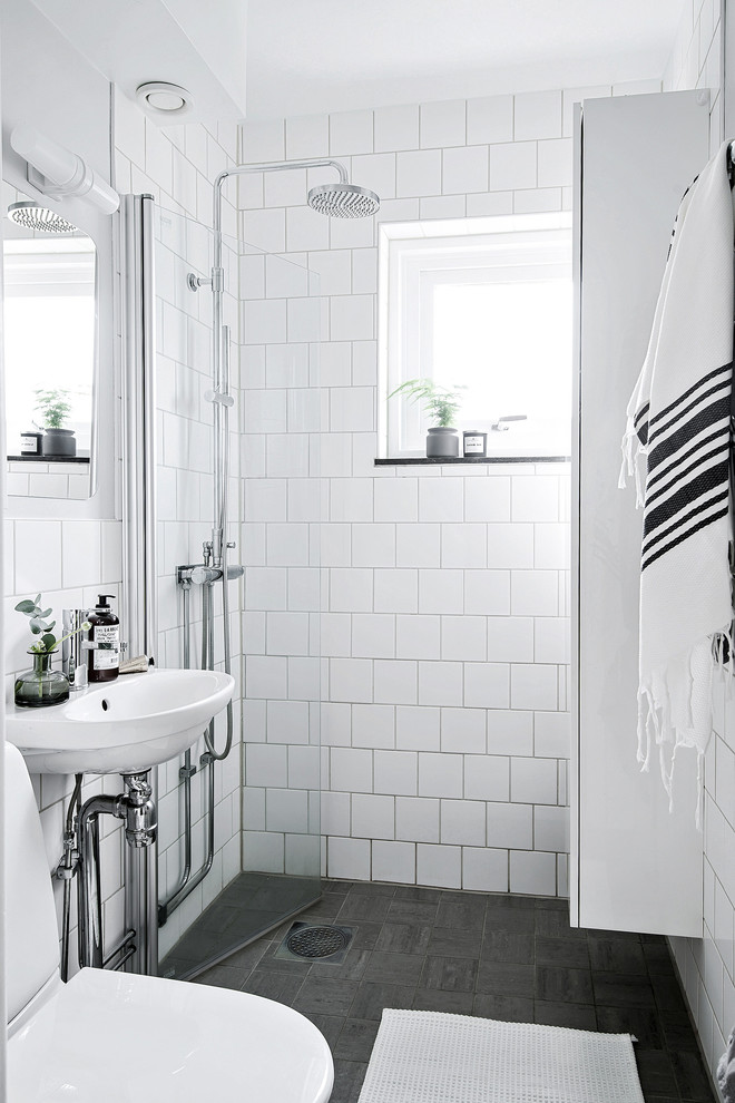 Scandinavian 3/4 bathroom in Gothenburg with a curbless shower, white tile, a wall-mount sink, grey floor and a hinged shower door.
