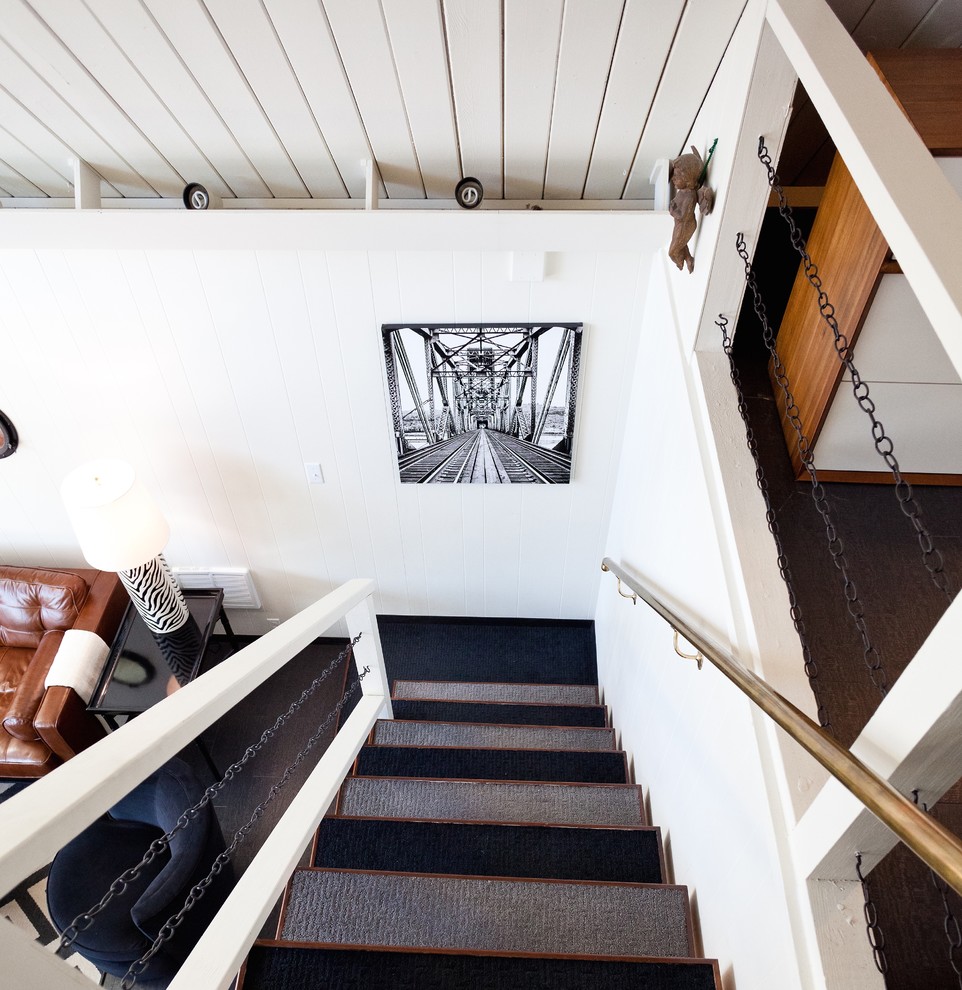 This is an example of a mid-sized eclectic carpeted straight staircase in Portland with open risers and mixed railing.