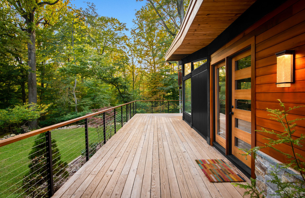 Свежая идея для дизайна: одноэтажный, деревянный, коричневый частный загородный дом среднего размера в стиле ретро с крышей-бабочкой и отделкой планкеном - отличное фото интерьера
