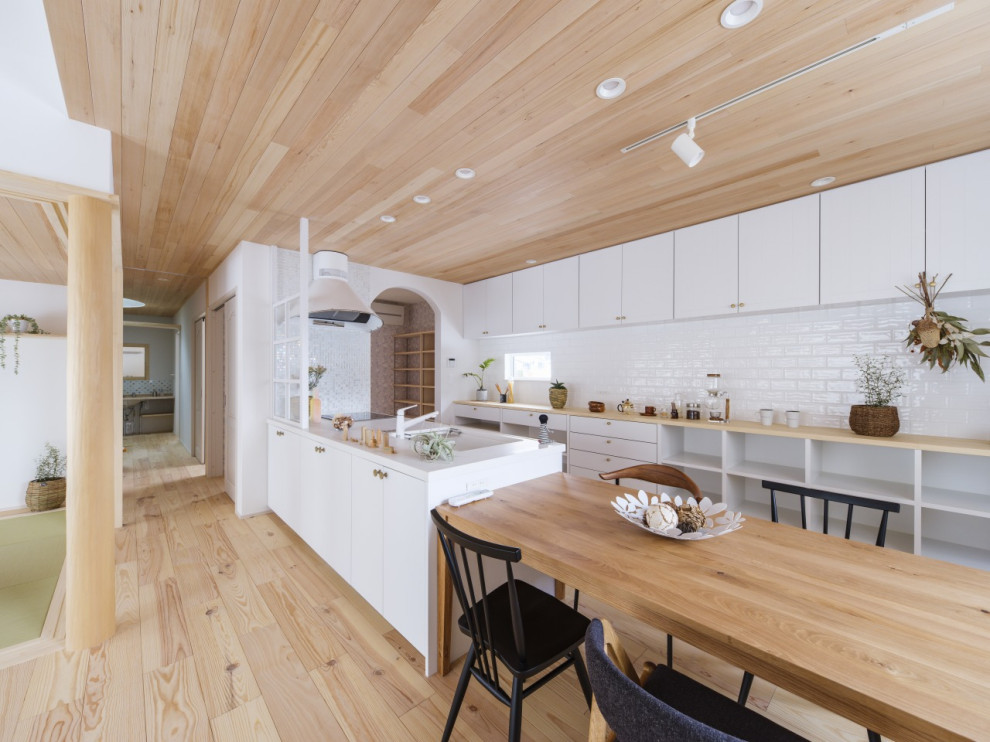 This is an example of a medium sized scandinavian single-wall open plan kitchen in Other with beaded cabinets, white cabinets, composite countertops, white splashback, white appliances, light hardwood flooring, an island, brown floors, white worktops and a wood ceiling.