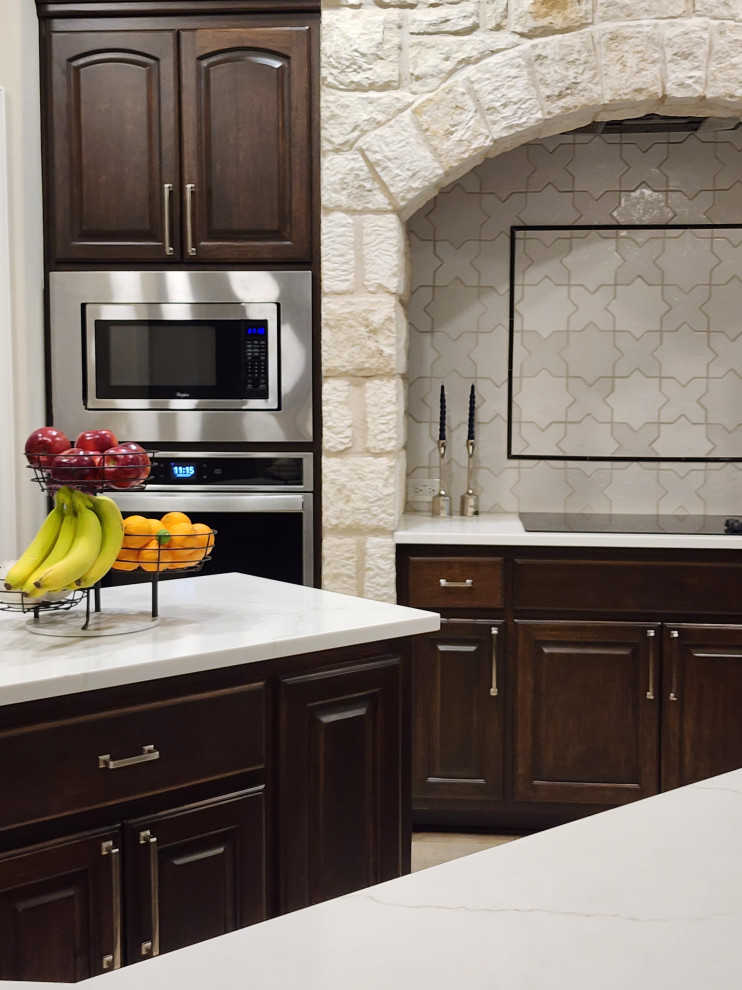 Open concept kitchen - mid-sized transitional l-shaped ceramic tile and beige floor open concept kitchen idea in Austin with a single-bowl sink, raised-panel cabinets, dark wood cabinets, quartz countertops, white backsplash, ceramic backsplash, stainless steel appliances, two islands and white countertops