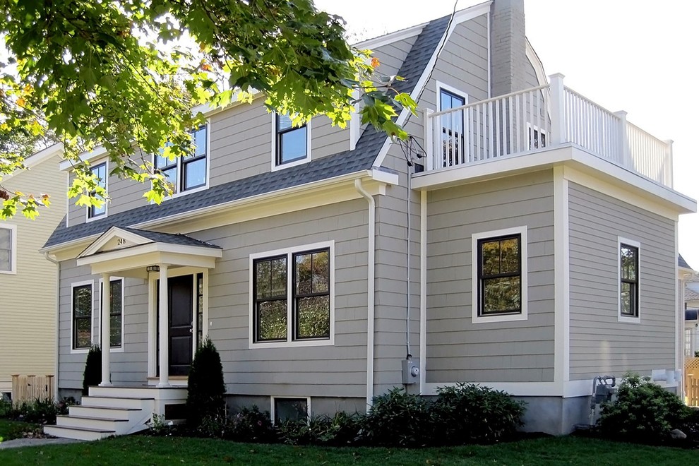This is an example of a mid-sized traditional three-storey grey house exterior in Boston with a gambrel roof, wood siding and a shingle roof.