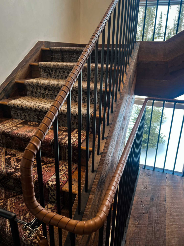 Imagen de escalera en L rústica con escalones de madera, contrahuellas de madera y barandilla de metal