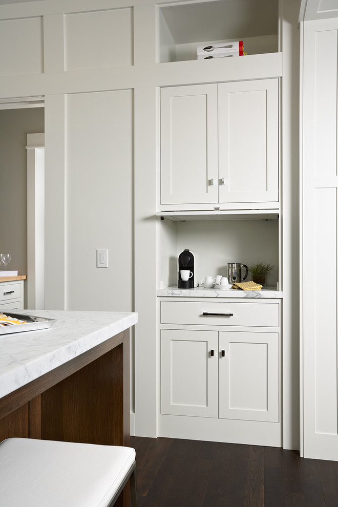 Open concept kitchen - large transitional dark wood floor open concept kitchen idea in Minneapolis with a farmhouse sink, recessed-panel cabinets, white cabinets, marble countertops, gray backsplash, ceramic backsplash, stainless steel appliances and an island